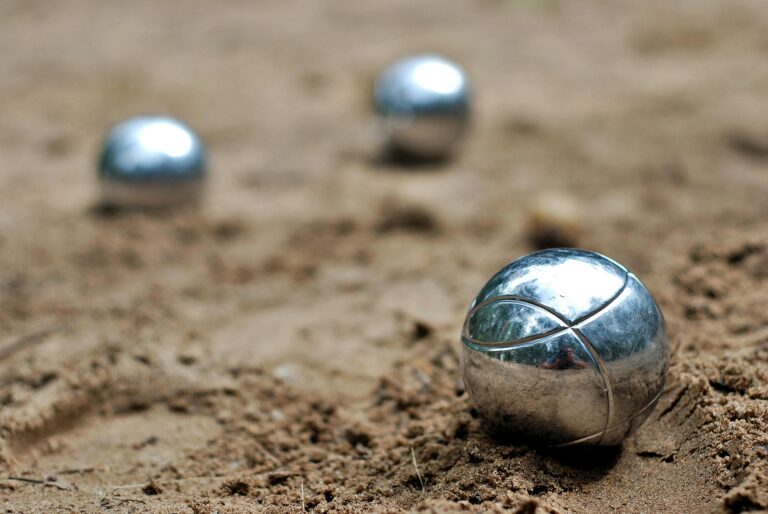 Close-up of shiny petanque balls on a sandy beach. Perfect for outdoor and leisure themes.